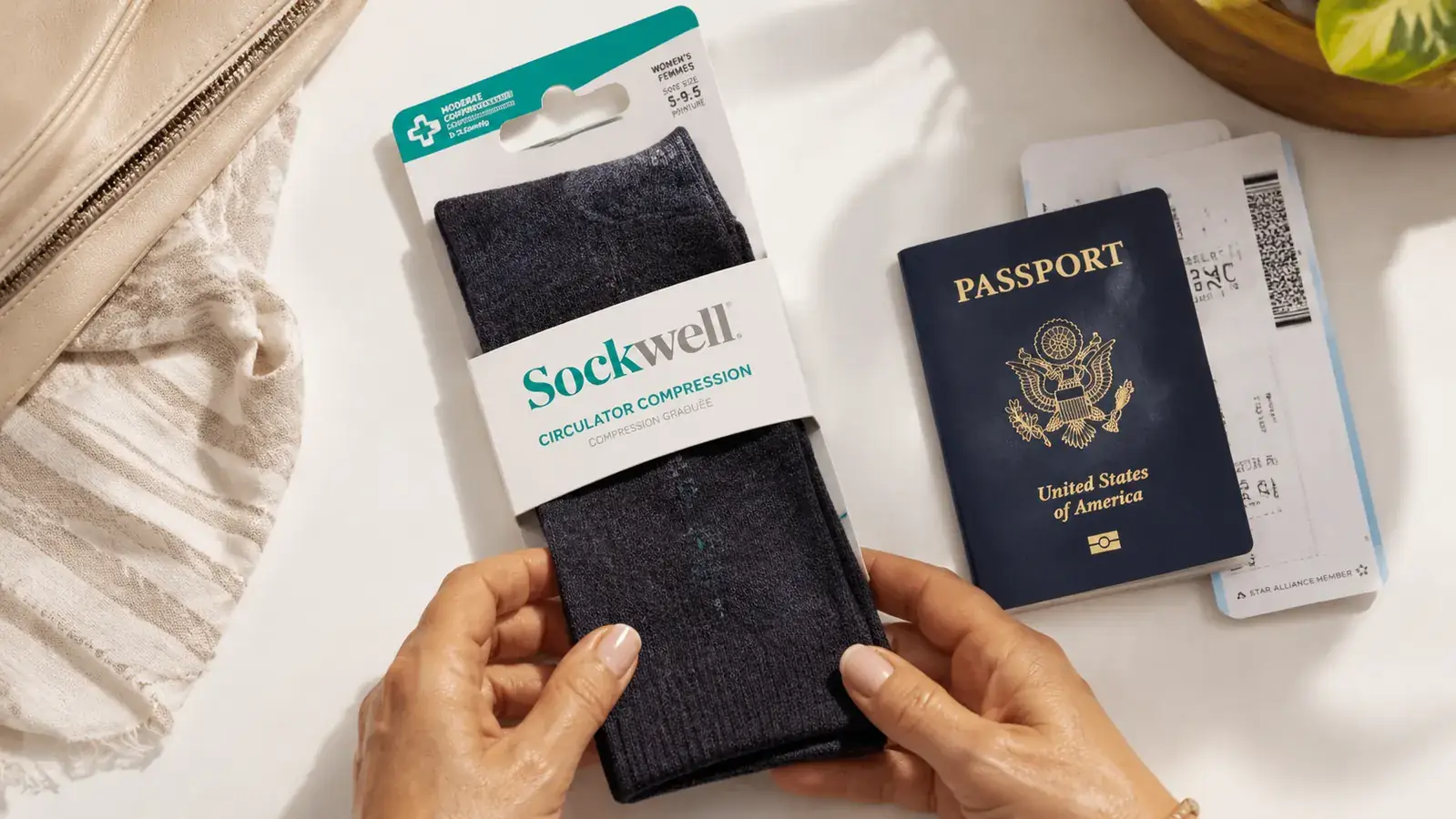 Close-up of Sockwell Circulator compression socks laid flat beside a passport and boarding pass