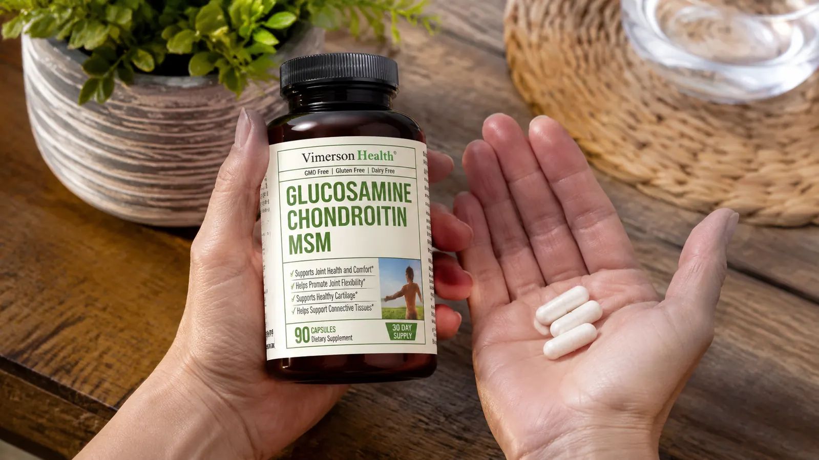 Close-up of glucosamine chondroitin MSM capsules being poured from a bottle into a hand