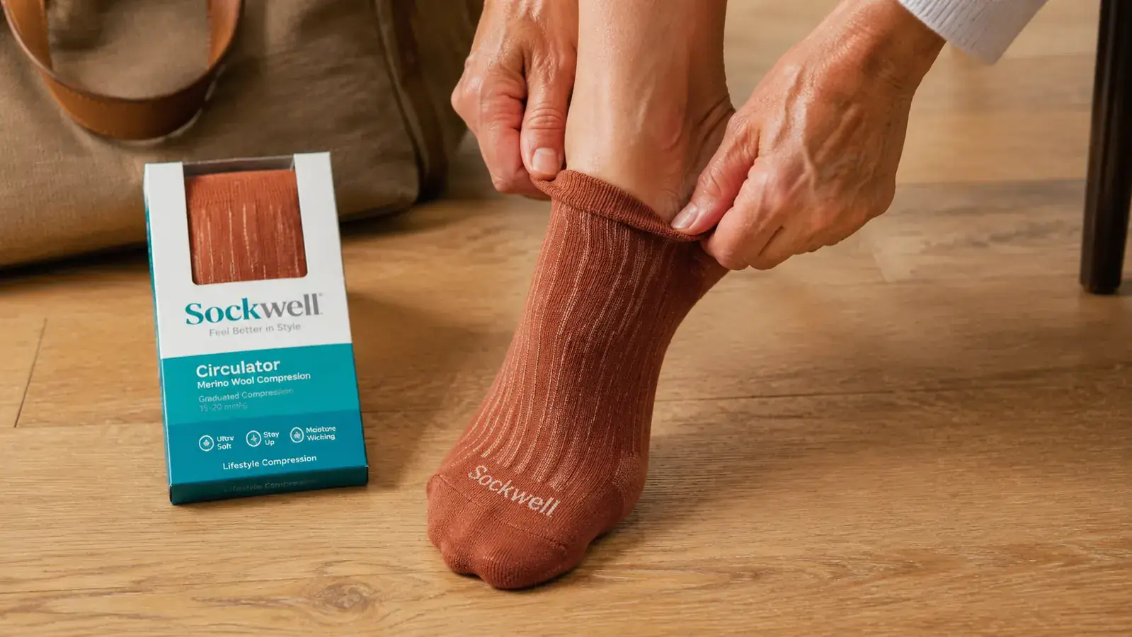 Close-up of Sockwell Circulator compression sock being pulled onto a foot, showing the graduated compression ribbing and merino wool texture